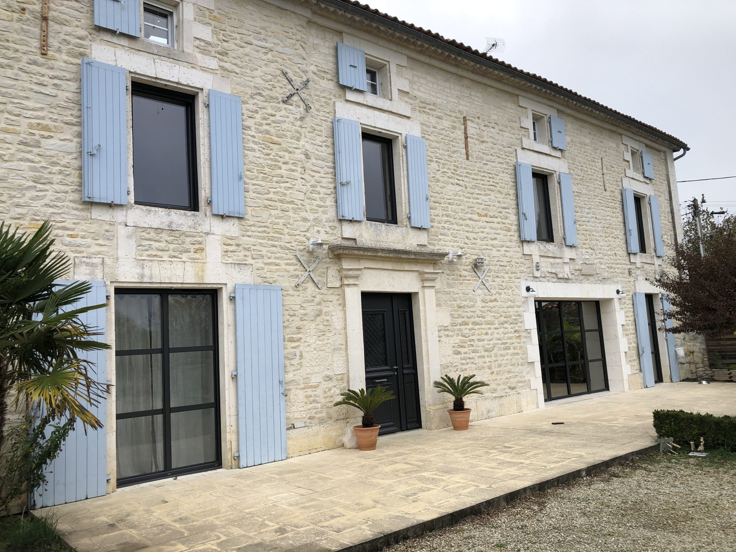 Maison en pierre avec volets bleus en France.