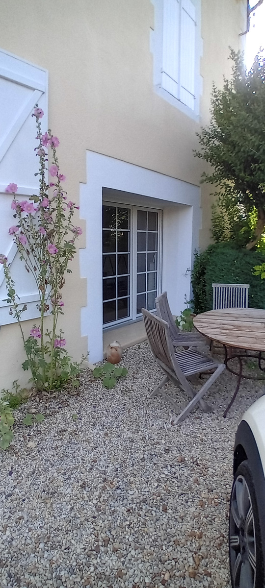 Jardin avec mobilier et fleurs devant la maison.