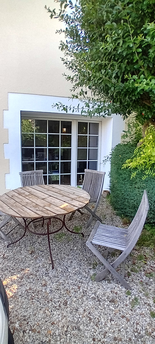 Table de jardin en bois avec quatre chaises.