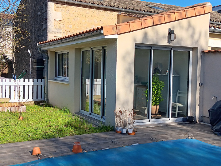 Maison avec jardin et piscine couverte.